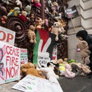 Parents and children lay out cuddly toys across the entrance to the Foreign Office, as they protest to save children's lives in Gaza. Each toy represents a Palestinian child killed during the Israel-Hamas conflict (Image: PA)