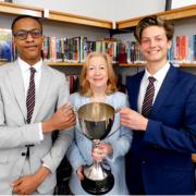 Epping Forest MP Dame Eleanor Laing presents the debating competition cup to Davenant Foundation School students Osaru Ayanru and Martin Prinsloo